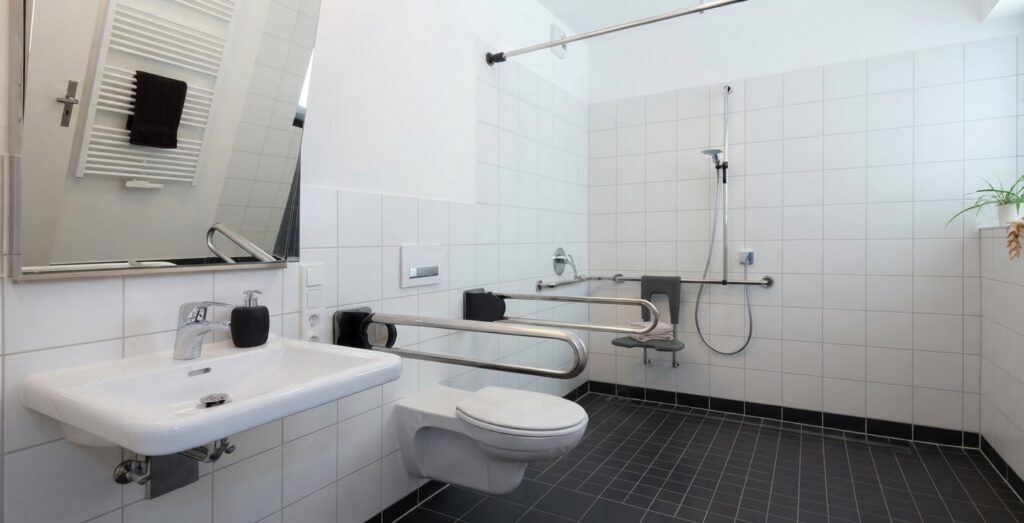 Un homme senior utilise une barre d'appui installée dans sa salle de bain adaptée pour faciliter ses gestes quotidiens. Un homme senior utilise une barre d'appui installée dans sa salle de bain adaptée pour faciliter ses gestes quotidiens.